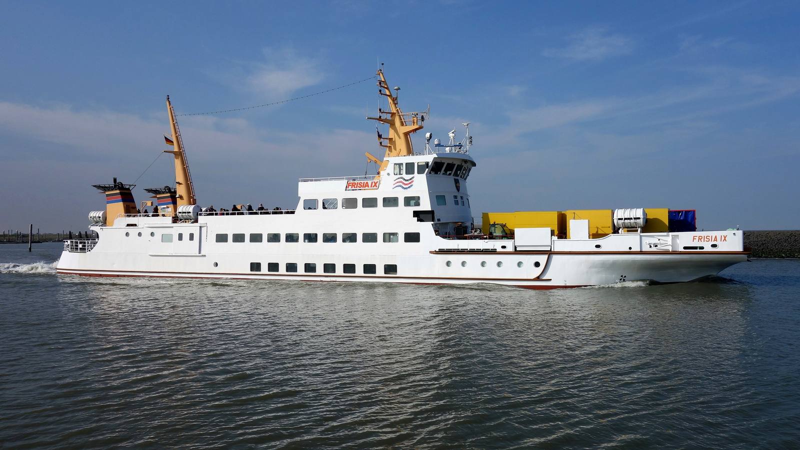 Die Inselfähre Frisia IX der Reederei Norden-Frisia auf dem Weg von Norddeich nach Juist, mit Gepäckcontainern an Deck